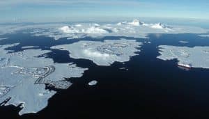 Aerial view of Antarctica showing research stations and pristine landscapes, illustrating potential business ideas in Antarctica